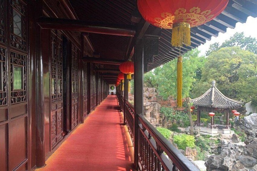 A corridor with red carpet, wooden doors, and red lanterns. 4