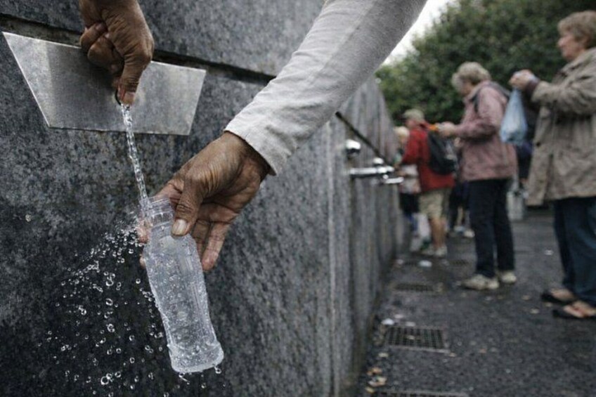 A person pouring water from a bottle into a metal container. 3