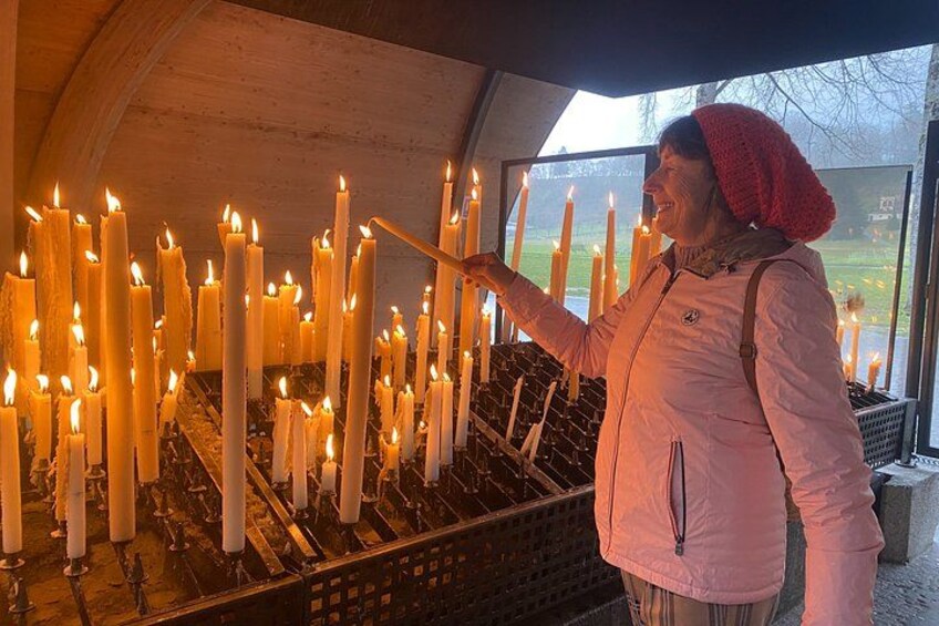 A person lighting candles in a church. 2