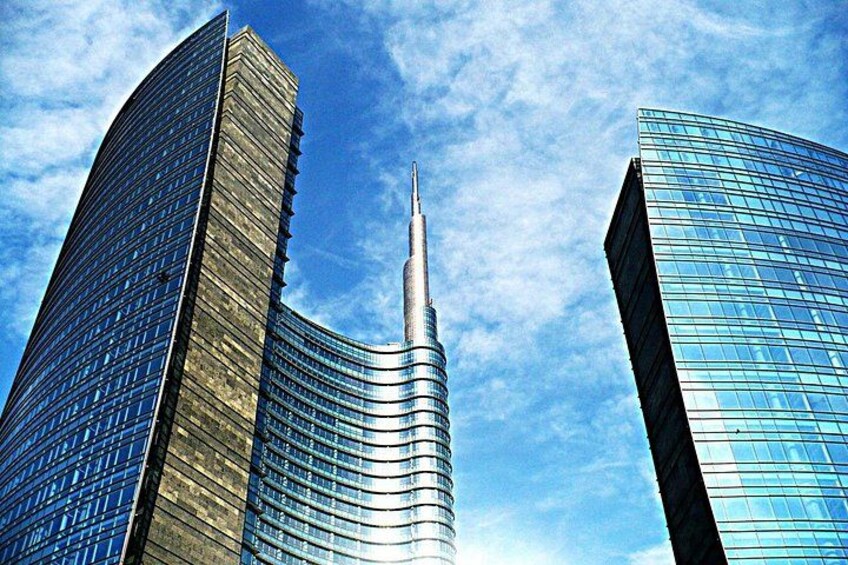 A cluster of modern skyscrapers with reflective glass facades and a clear blue sky. 3