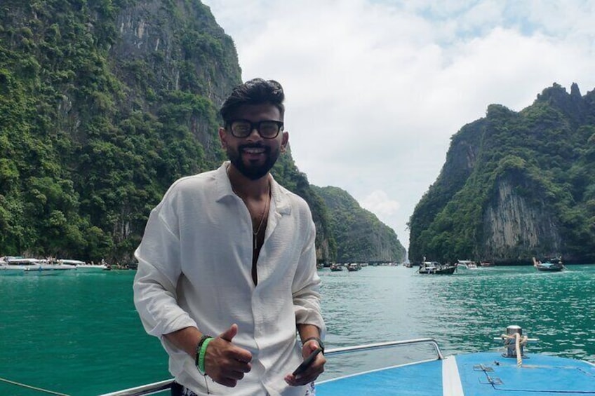 Eine Person in einem Boot auf einem schmalen Kanal, umgeben von steilen Klippen. 4