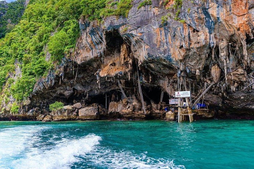 A rocky coastal landscape with clear turquoise water, a wooden platform, and a sign. 4