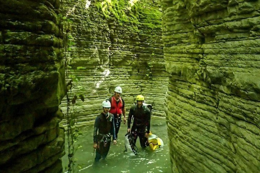 A narrow canyon with rocky walls and water. 3