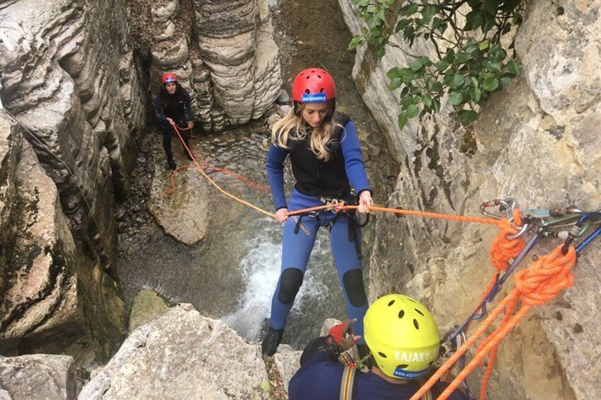 A person rappelling down a rocky cliff with ropes and harnesses. 3
