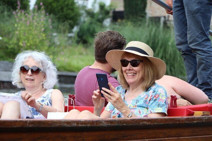 People in a boat, a wooden dock, and greenery in the background. 2