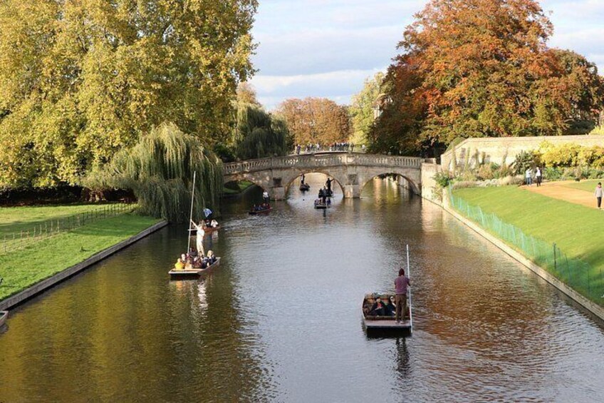 A river with boats, a bridge, and trees. 5