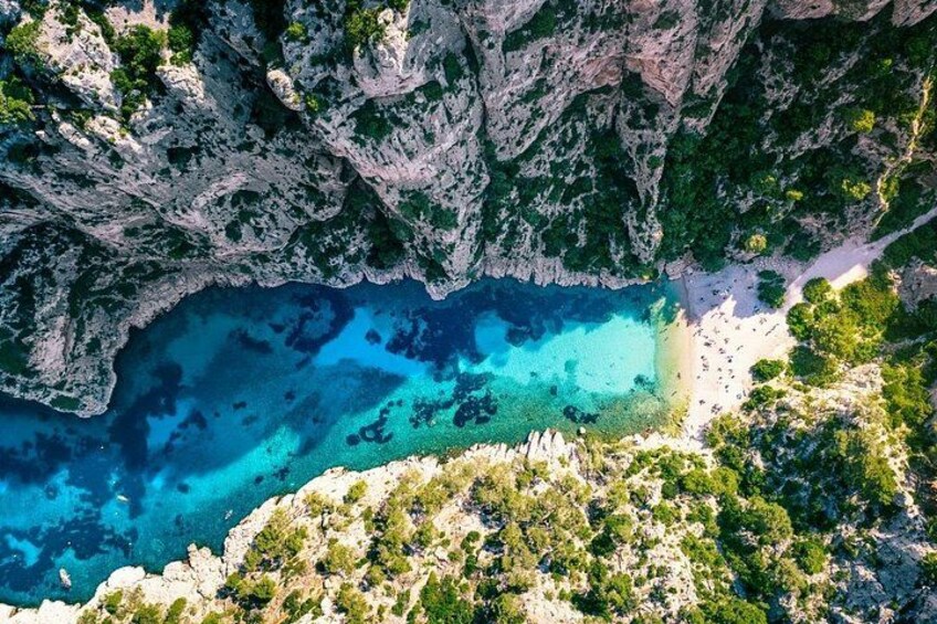 Un paysage côtier avec une mer bleue et limpide, des falaises rocheuses et une plage de sable. 4