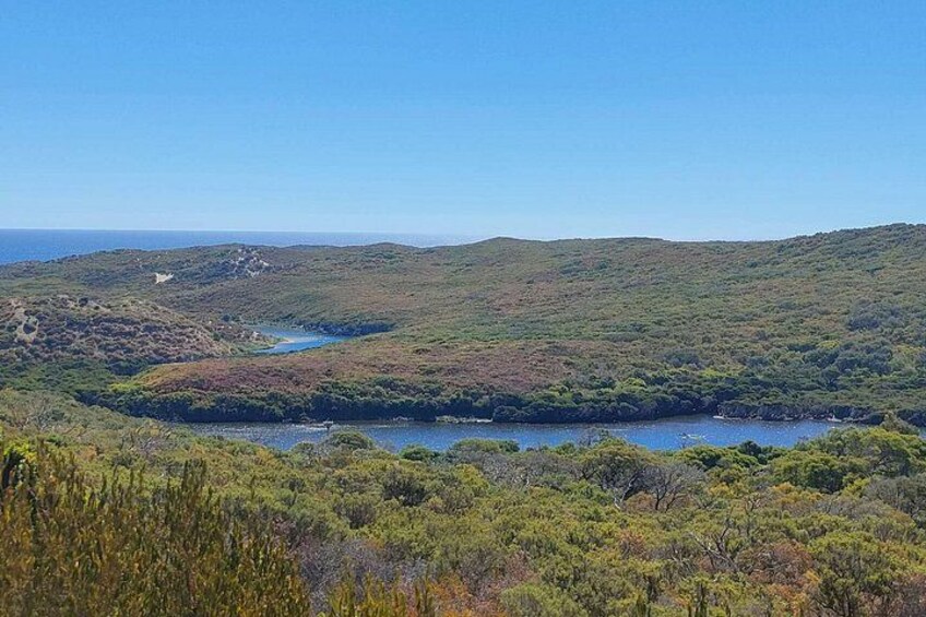 Un paysage côtier caractérisé par des collines, un lac et une végétation luxuriante. 2