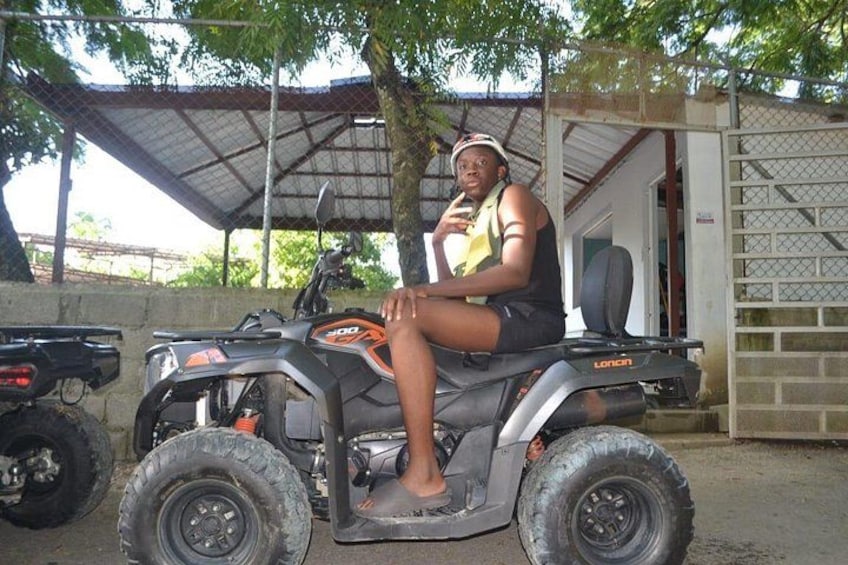 A person sitting on an ATV with a canopy in the background. 4