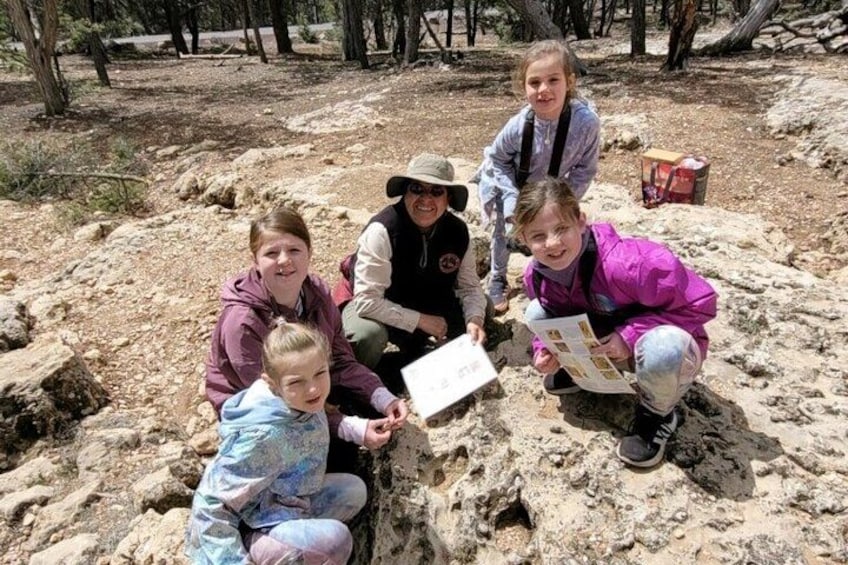 A group of people examining a rock formation outdoors. 2