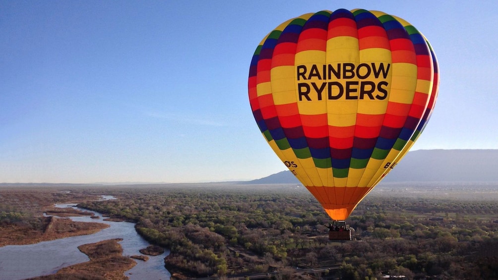 Hot air balloon over a river at dusk in Albuquerque