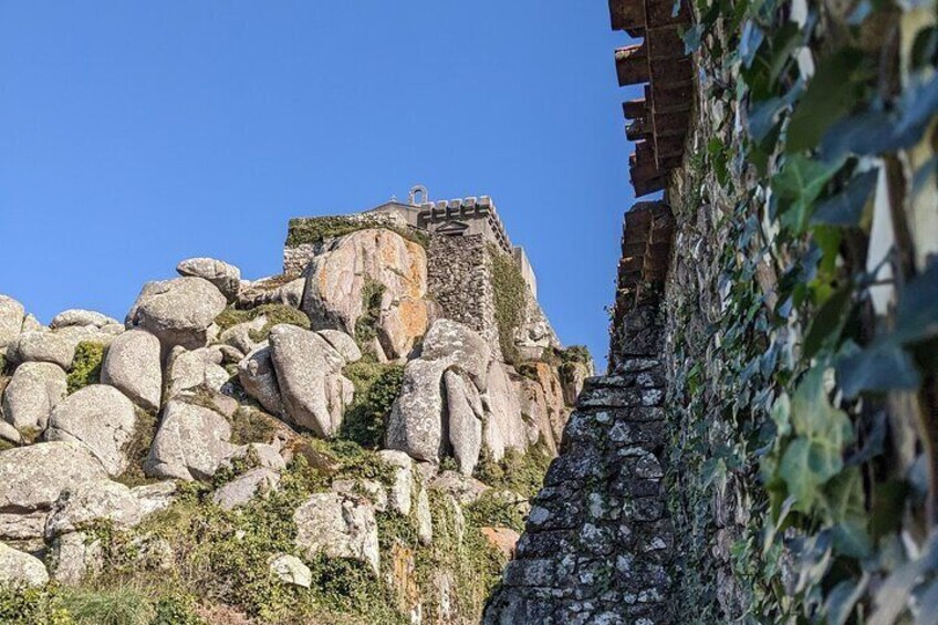 Un mur de pierres, composé de gros blocs, et un escalier menant à une construction située sur une colline. 3