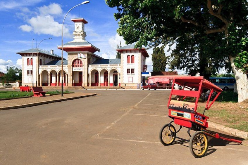 Un bâtiment doté d’une tour, d’un chariot rouge et d’un parking. 2