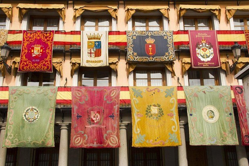 Fachada de edificio con múltiples banderines, cada uno con emblemas y diseños diferentes. 4
