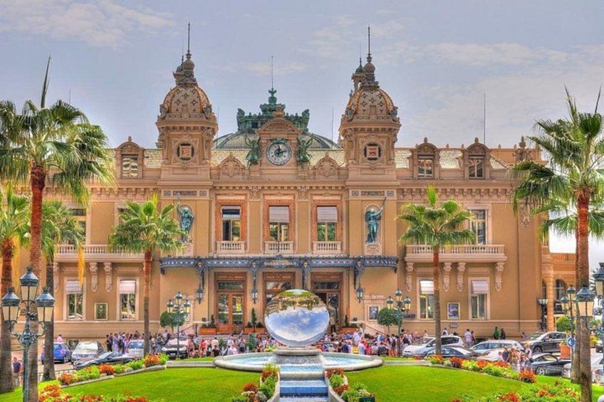 A large, ornate building with two towers, a fountain, and palm trees. 3