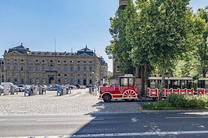 En spårvagnshållplats med en historisk byggnad i bakgrunden. 5