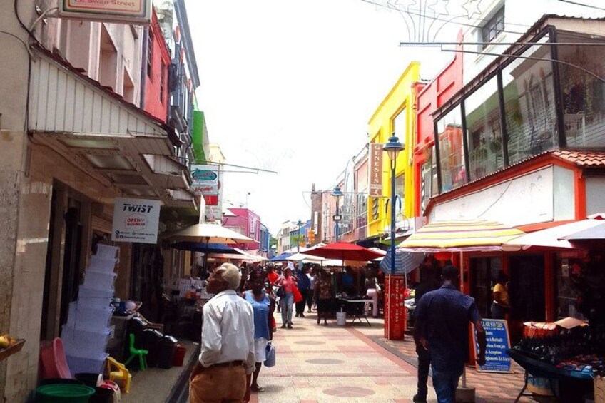 Un mercado callejero animado con edificios coloridos y gente comprando. 4