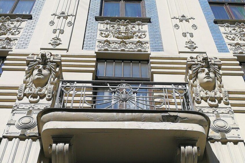 An ornate building facade with intricate carvings and a balcony. 2
