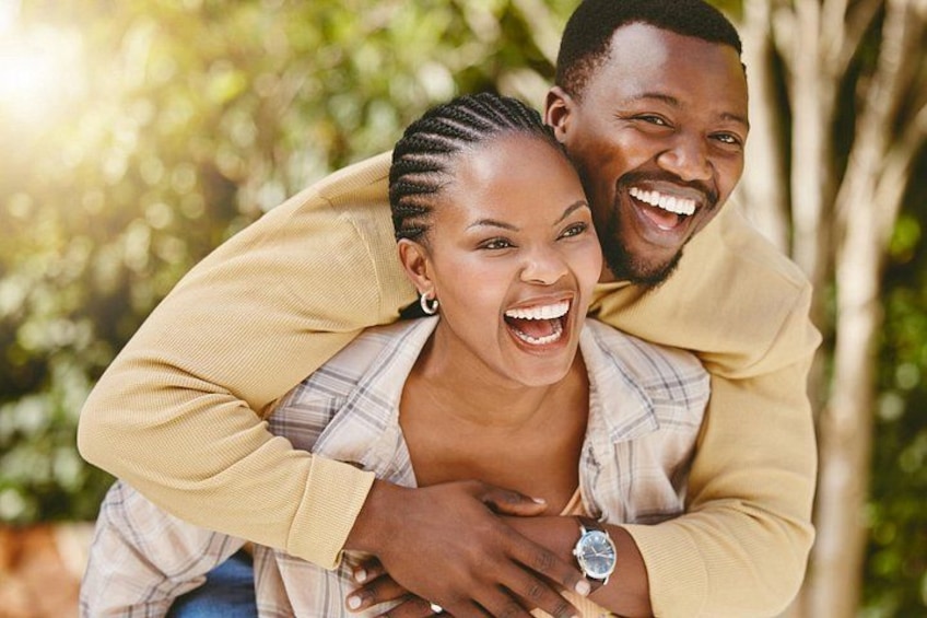 A couple embracing in a natural setting with trees and sunlight. 1
