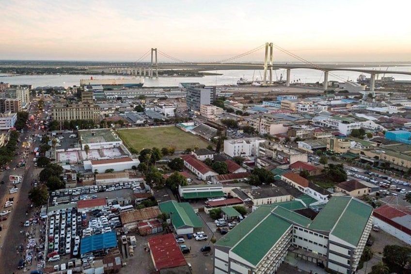 A cityscape with a large bridge, buildings, and a parking lot. 2