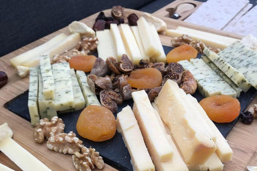 Variedad de quesos y frutos secos sobre una tabla de madera. 2