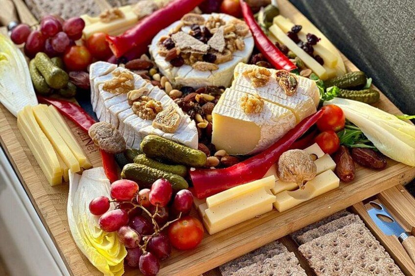 Una tabla de fiambres con diversos quesos, frutas y frutos secos. 1