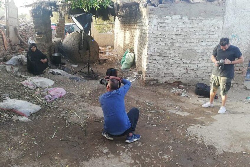 A person taking a photo in an outdoor setting with a makeshift studio setup. 2