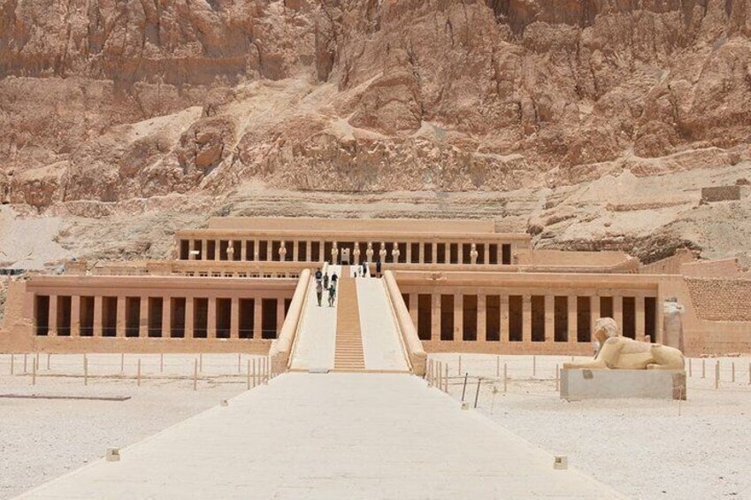 A large ancient Egyptian temple with a long central corridor and a sphinx statue. 1