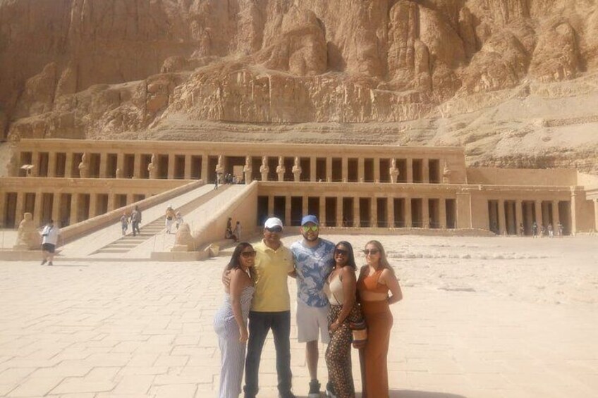 A group of people standing in front of a large ancient Egyptian temple with a grand staircase leading up to it. 3