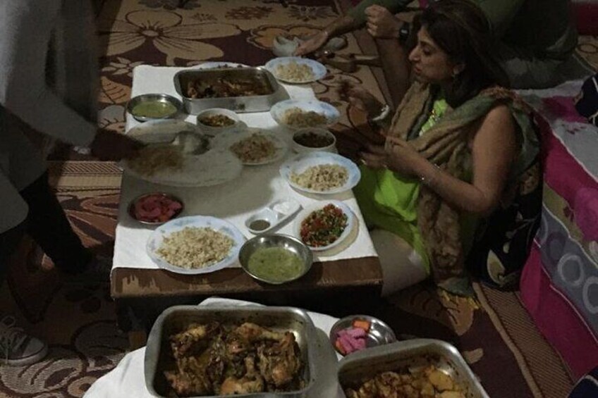 A dining table with various dishes, including rice, curries, and a meat dish. 4