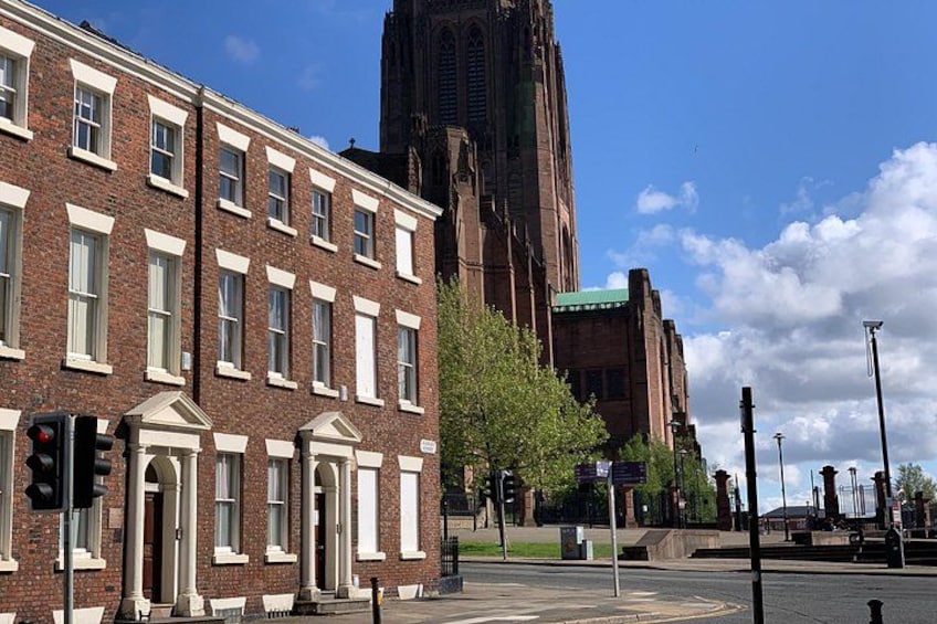 Een straat met een gebouw van rode bakstenen, een kerktoren en een helderblauwe lucht. 3
