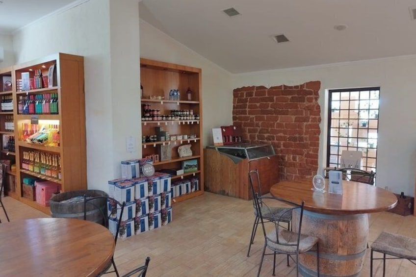 Una habitación con estanterías de madera, una pared de ladrillo y una mesa redonda con sillas. 3