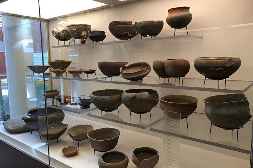 Una exhibición de museo con cerámica antigua. 2