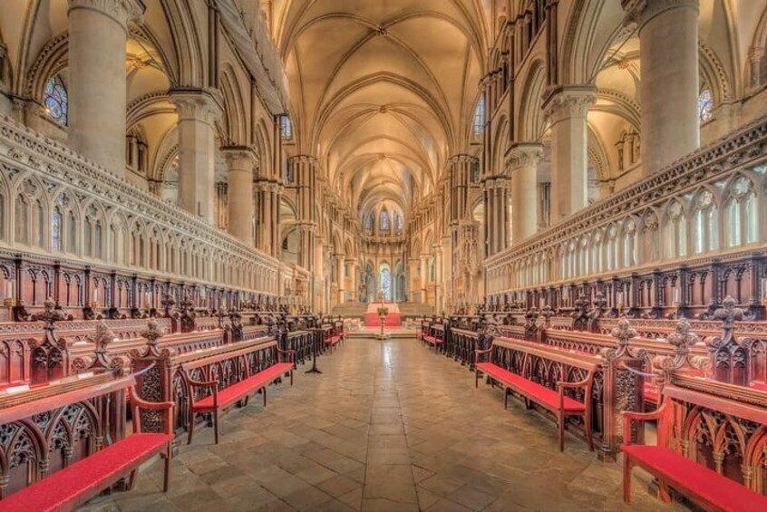 A cathedral interior with high vaulted ceilings, rows of pews, and intricate stone carvings. 5