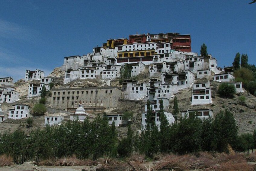 A cluster of white buildings on a hillside with a prominent red structure on top. 2
