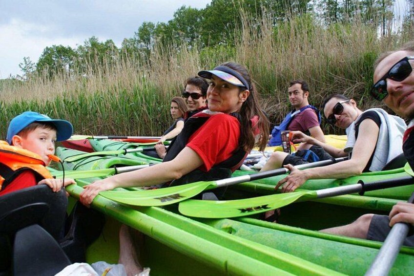 People in green kayaks on a river. 1
