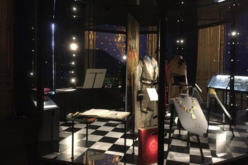 Una exhibición de museo con maniquíes, un suelo a cuadros y una vitrina. 2