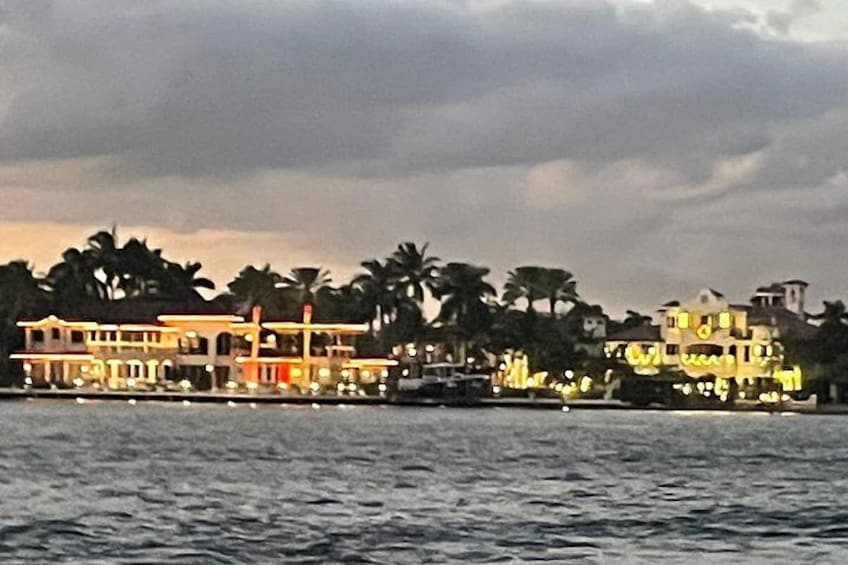 A waterfront property with multiple buildings, palm trees, and a body of water. 3