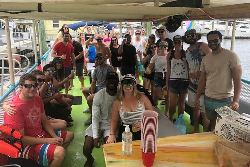 A group of people on a boat with a table and stacked cups. 4