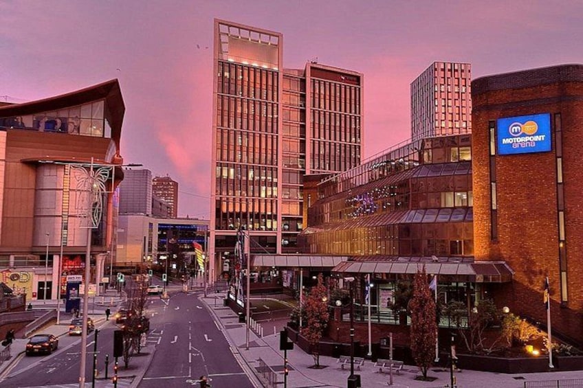 Una calle urbana con edificios modernos, un rótulo Motorpoint y cielo despejado. 4