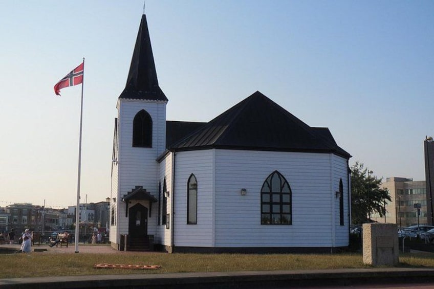 Una iglesia blanca con campanario y una bandera. 2