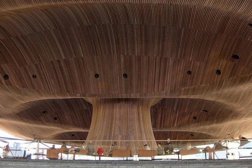 Una gran estructura de madera con techo abovedado y múltiples aberturas. 5