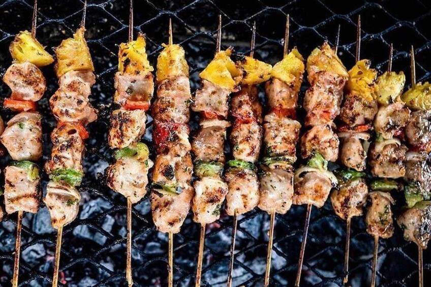 A variety of skewers with grilled meat and vegetables on a grill. 2