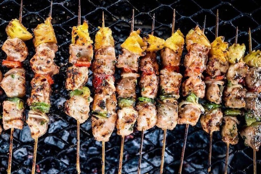 A variety of grilled skewers with meat and vegetables on a grill. 2