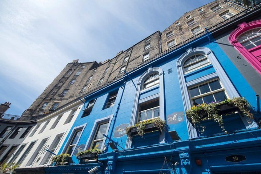 A blue building with arched windows and a pink corner. 4