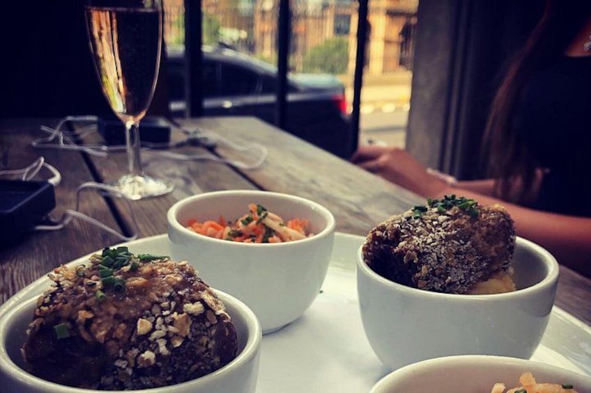 A table with three bowls of food and a glass of wine. 5