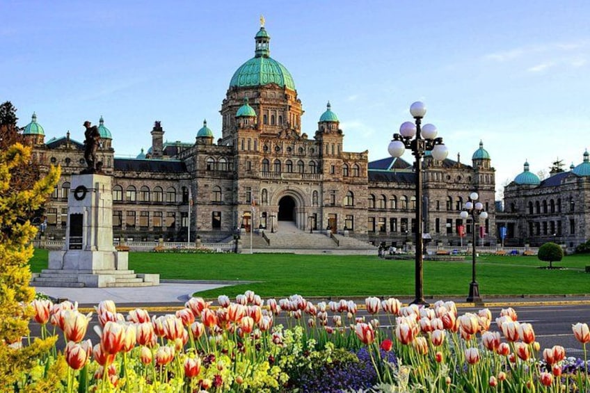A historic building with a large dome and multiple smaller domes, surrounded by a well-maintained lawn and a variety of tulips. 3