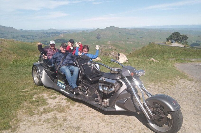 Una motocicleta con pasajeros circulando por un camino de tierra rodeado de colinas. 2