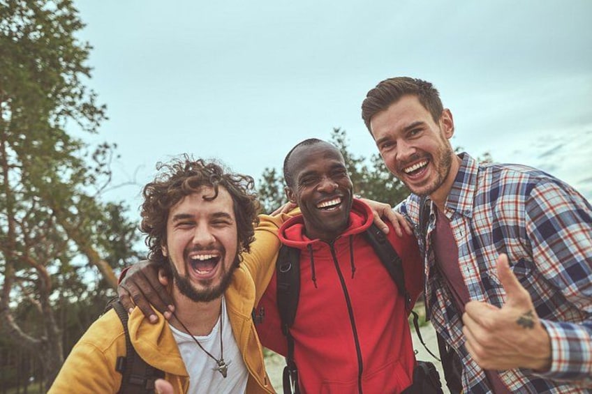 Three people outdoors, one giving a thumbs-up. 2