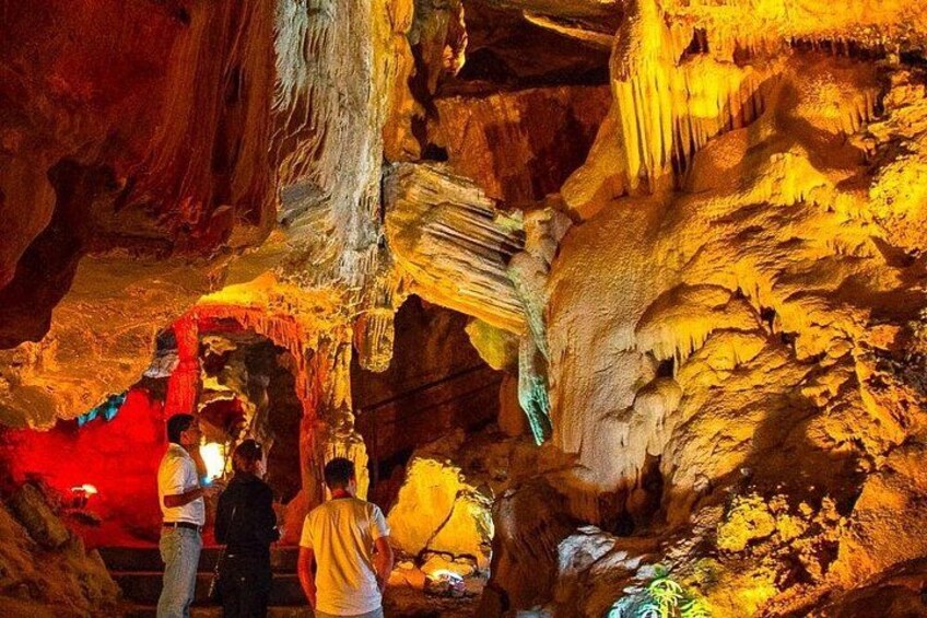 A cave with stalactites and stalagmites, illuminated by artificial lighting. 4